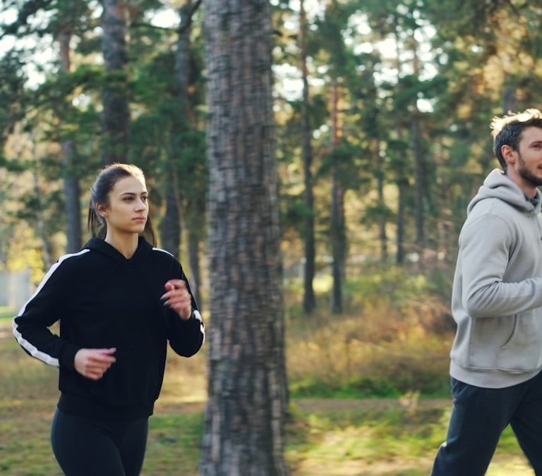 Man and woman jogging together in a park.